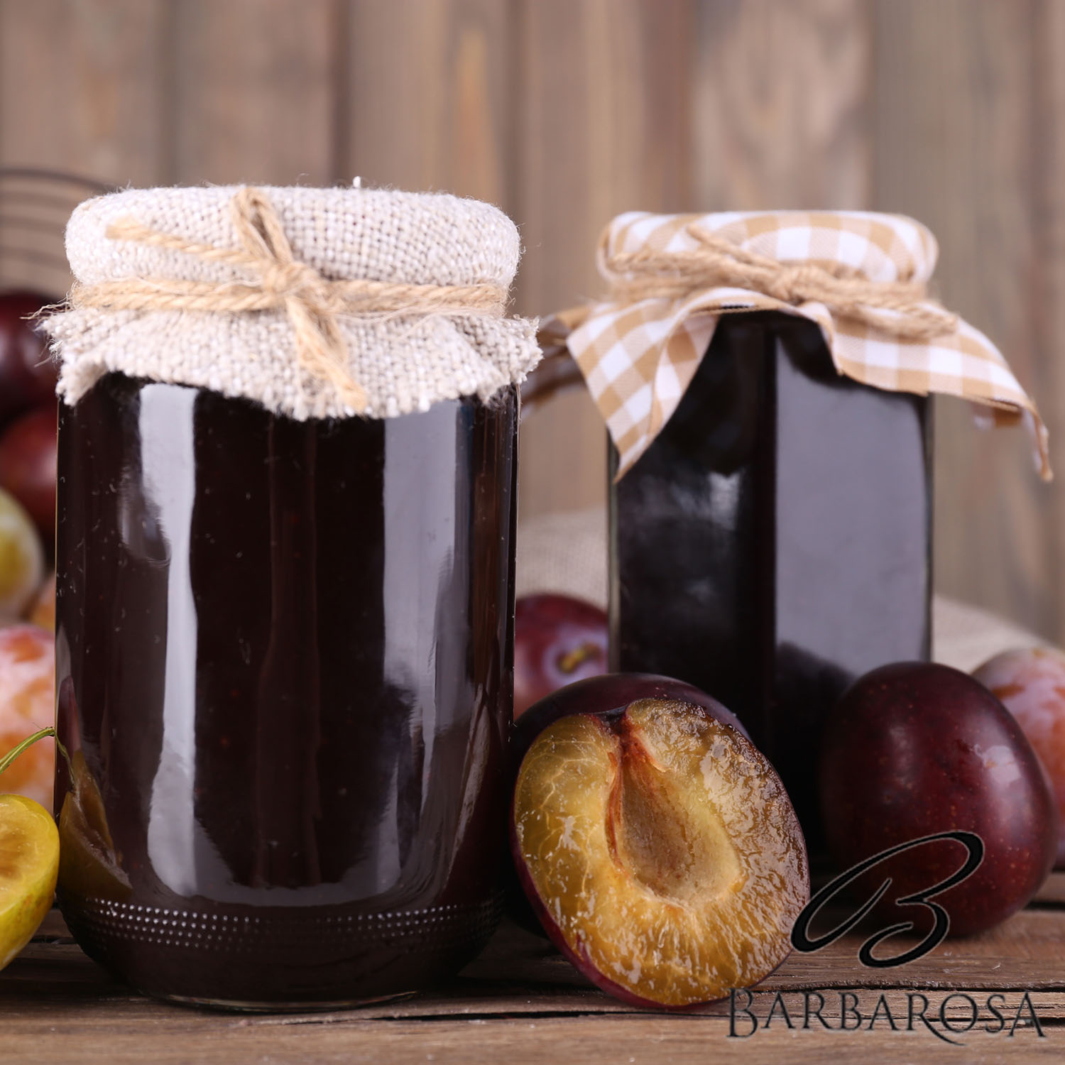 Tasty plum jam in jars and plums on wooden table on wooden backg