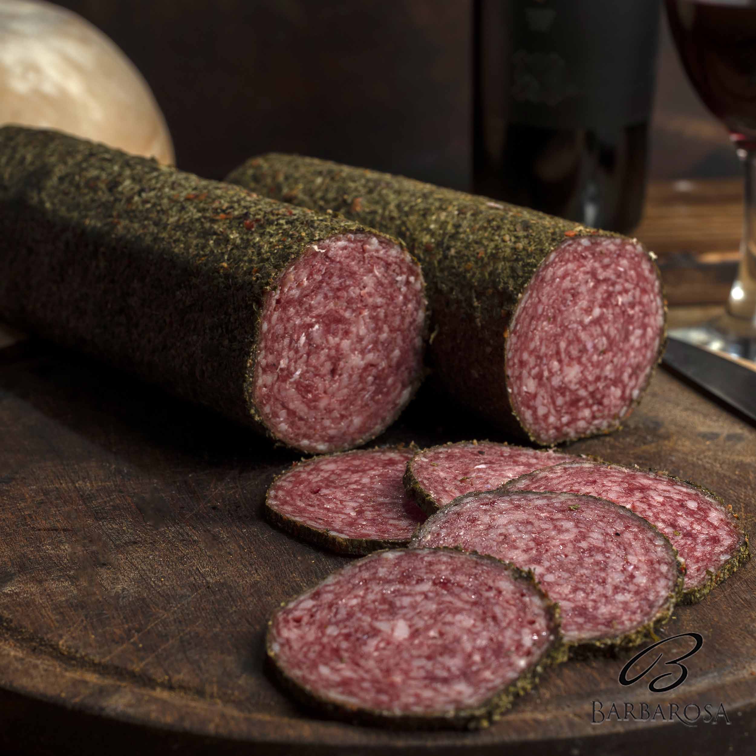 Closeup shot of rolls of smoked salami meat on a wooden board